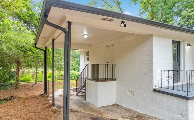 a backyard of a house with plants and large trees