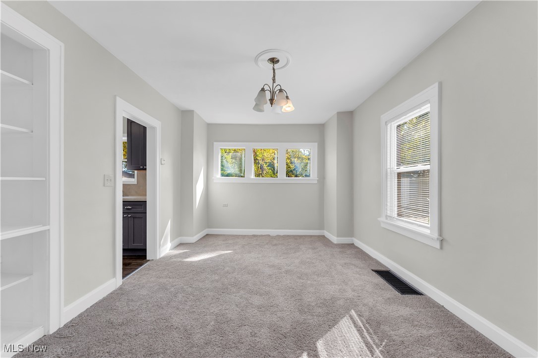 945 Nela View Road Cleveland Heights, OH 44112 - Photo 9 of 27 Carpeted empty room featuring a chandelier and baseboards