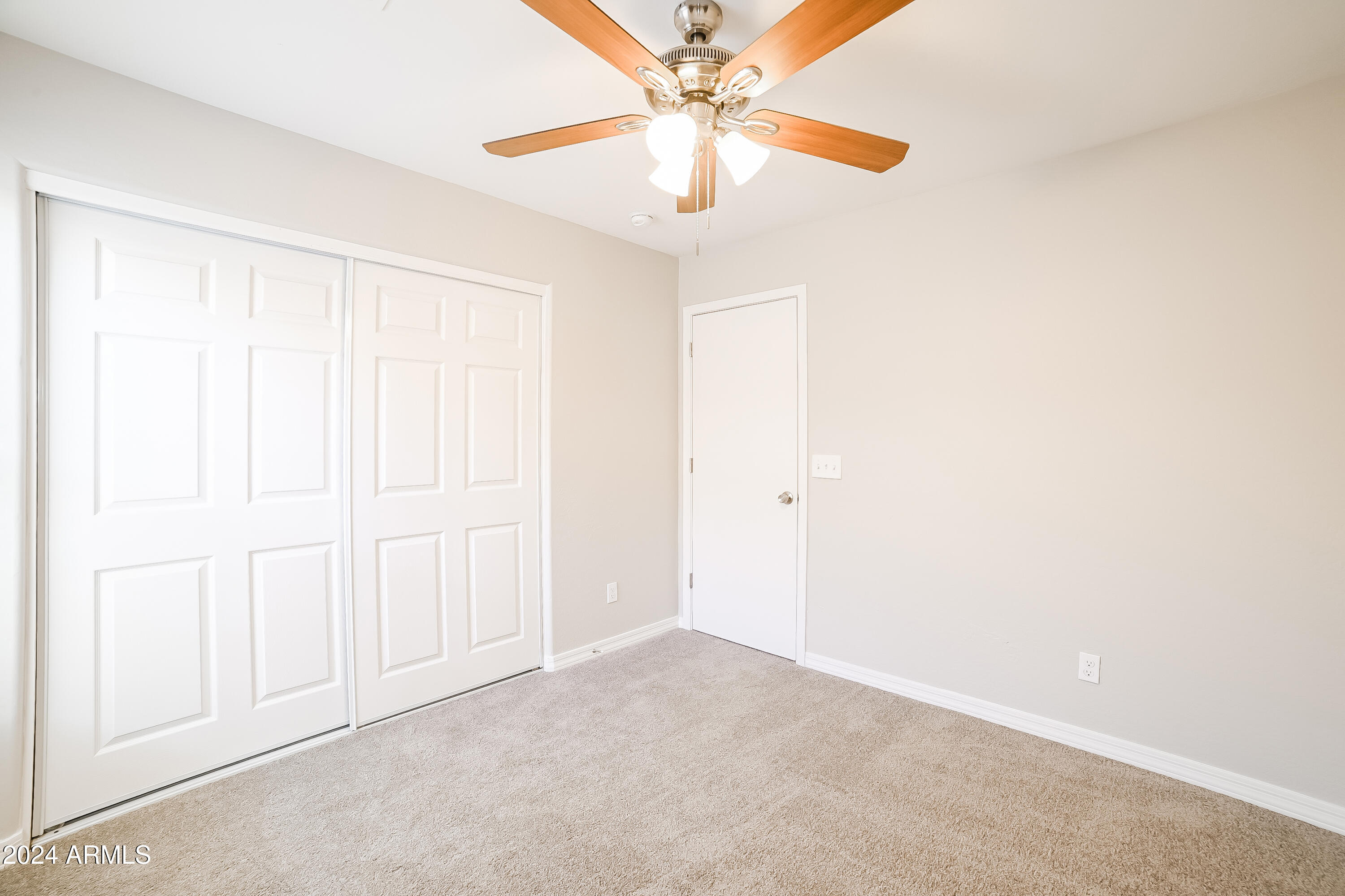 41402 Hopper Drive Maricopa, AZ 85138 - Photo 13 of 16 an empty room with closet and a chandelier fan