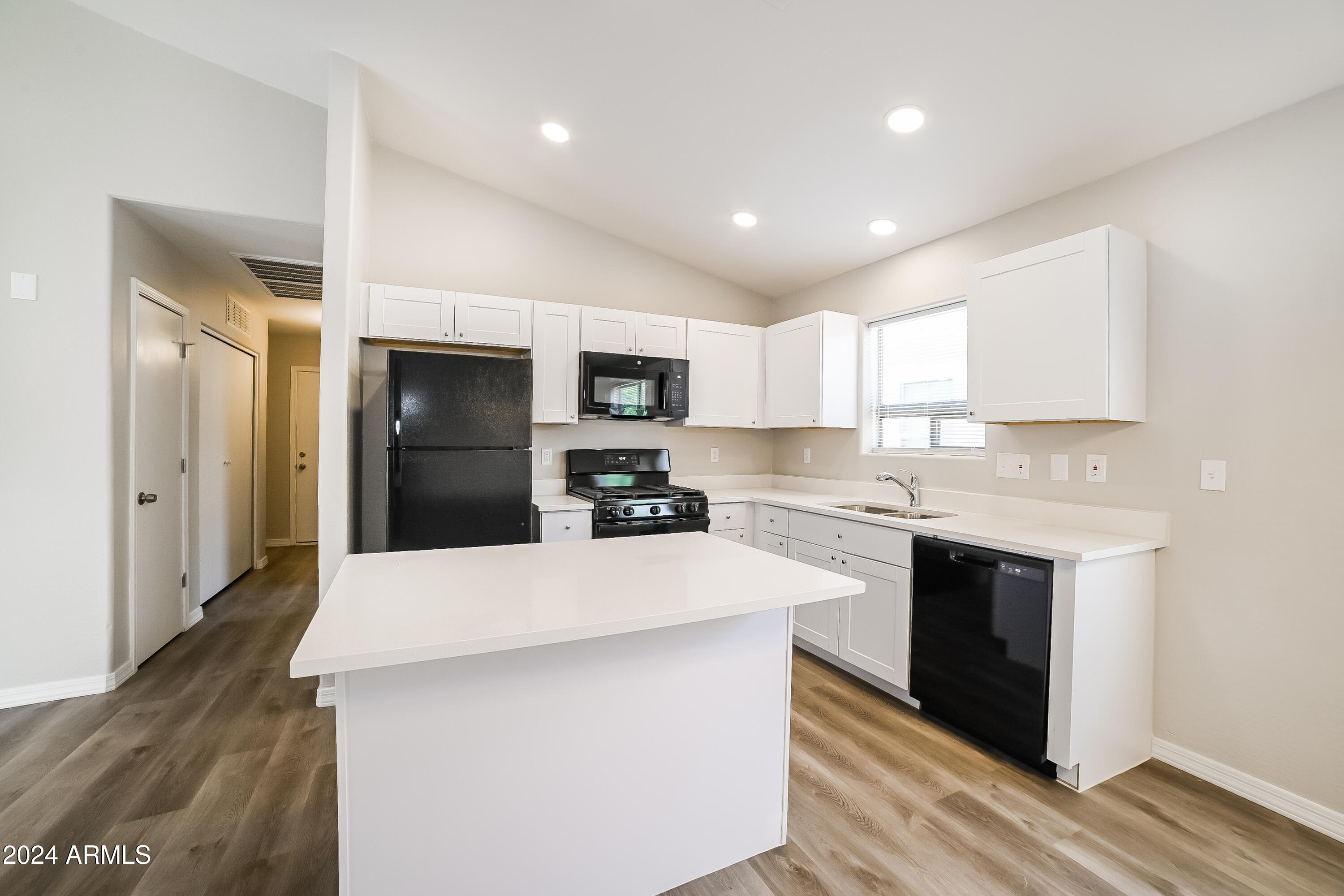 41402 Hopper Drive Maricopa, AZ 85138 - Photo 4 of 16 a kitchen with kitchen island a sink stainless steel appliances and cabinets