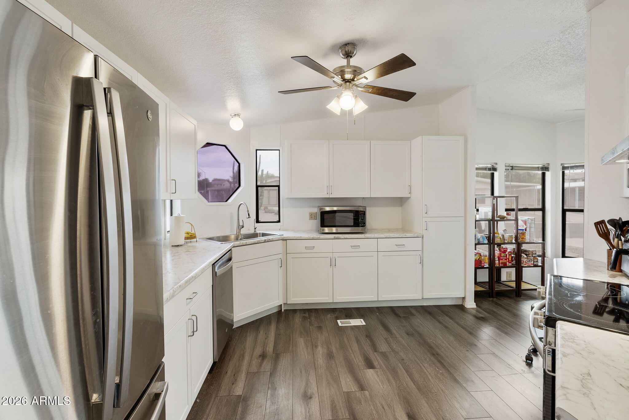 456 South 83rd Way Mesa, AZ 85208 - Photo 5 of 40 a kitchen with white cabinets and stainless steel appliances