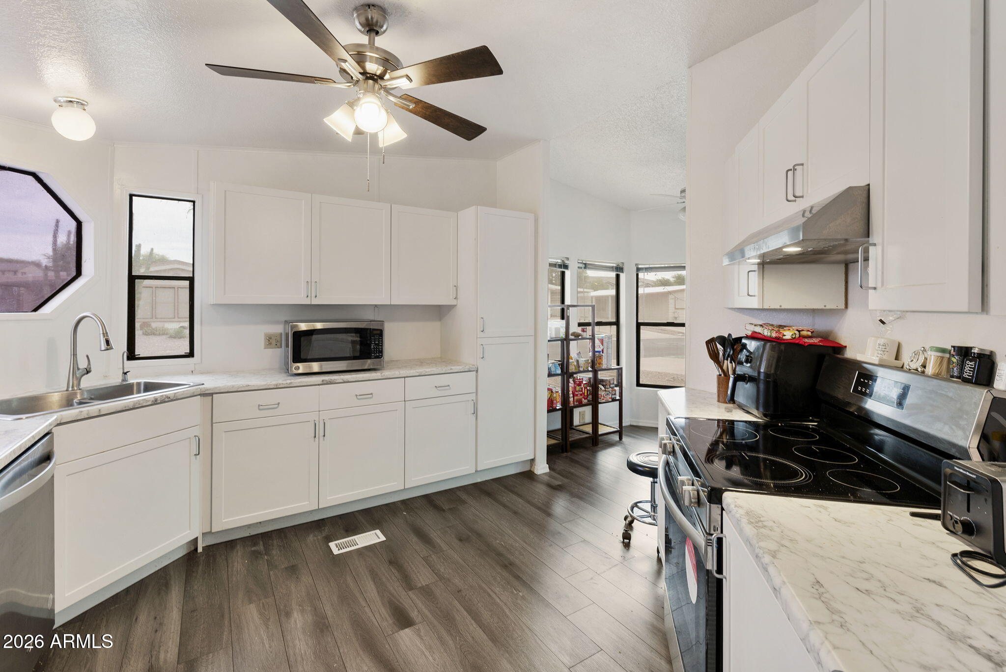 456 South 83rd Way Mesa, AZ 85208 - Photo 6 of 40 a kitchen with a stove a sink and a refrigerator
