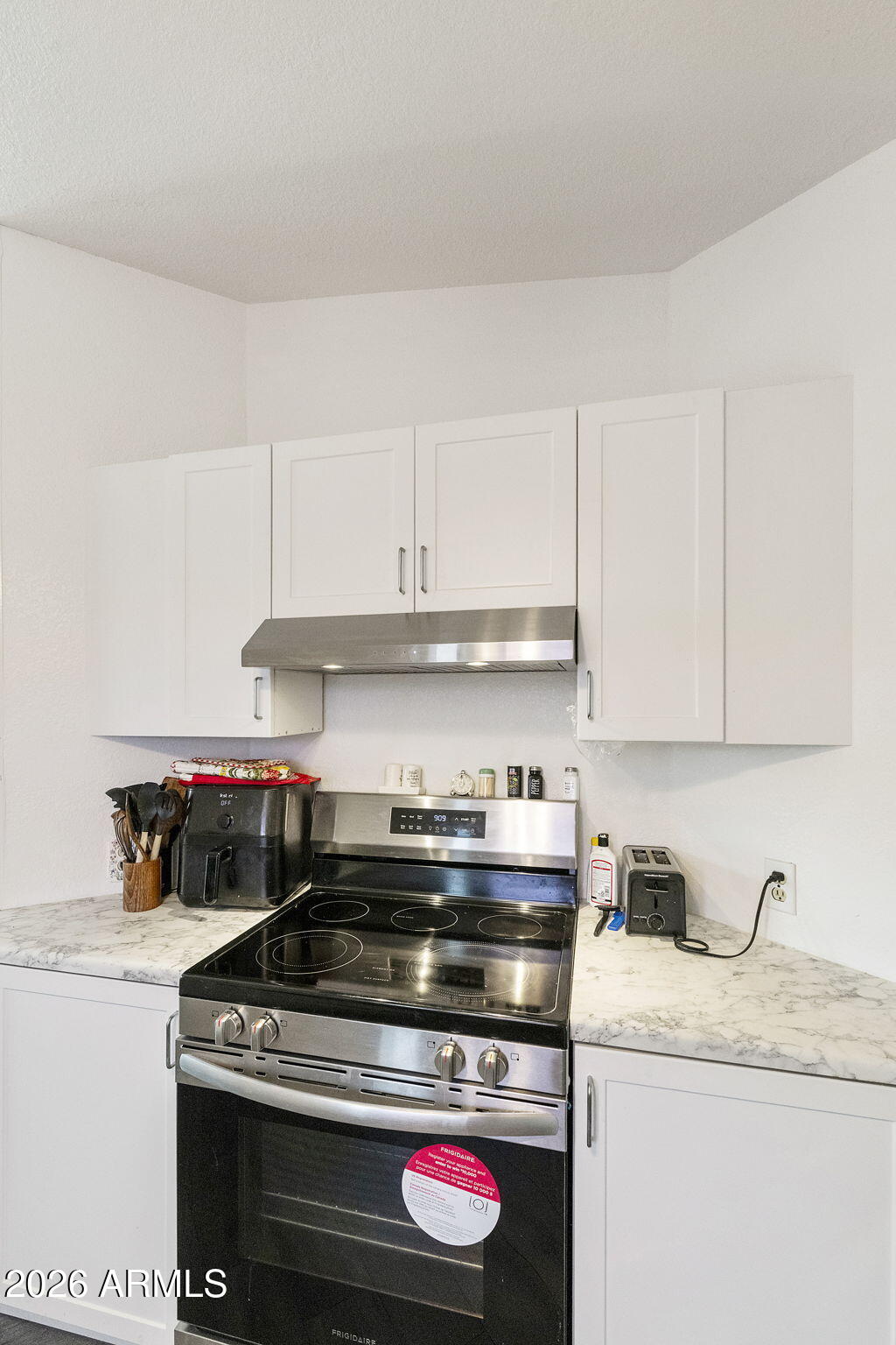 456 South 83rd Way Mesa, AZ 85208 - Photo 7 of 40 a kitchen with granite countertop a stove and a white cabinets