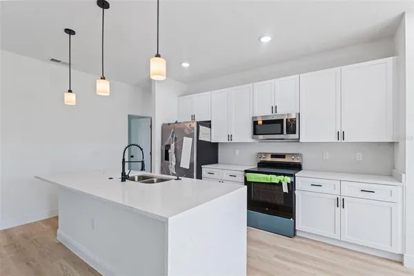 a kitchen with stainless steel appliances and white cabinets
