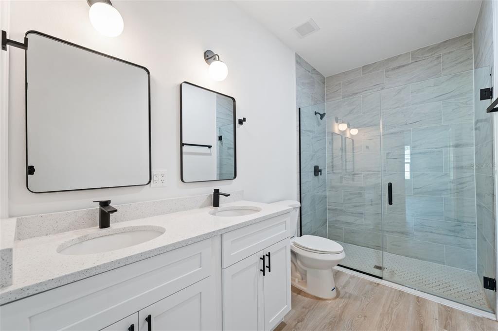 3479 Southwest 137th Loop Ocala, FL 34473 - Photo 19 of 32 a bathroom with a double vanity sink toilet mirror and shower