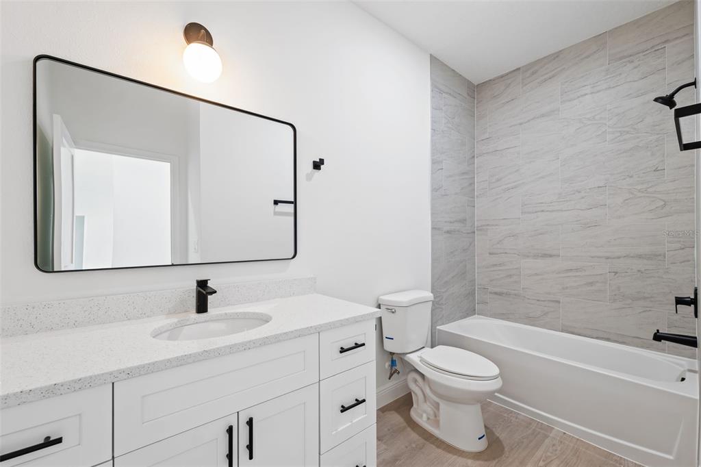 3479 Southwest 137th Loop Ocala, FL 34473 - Photo 22 of 32 a bathroom with a toilet a sink a mirror and shower