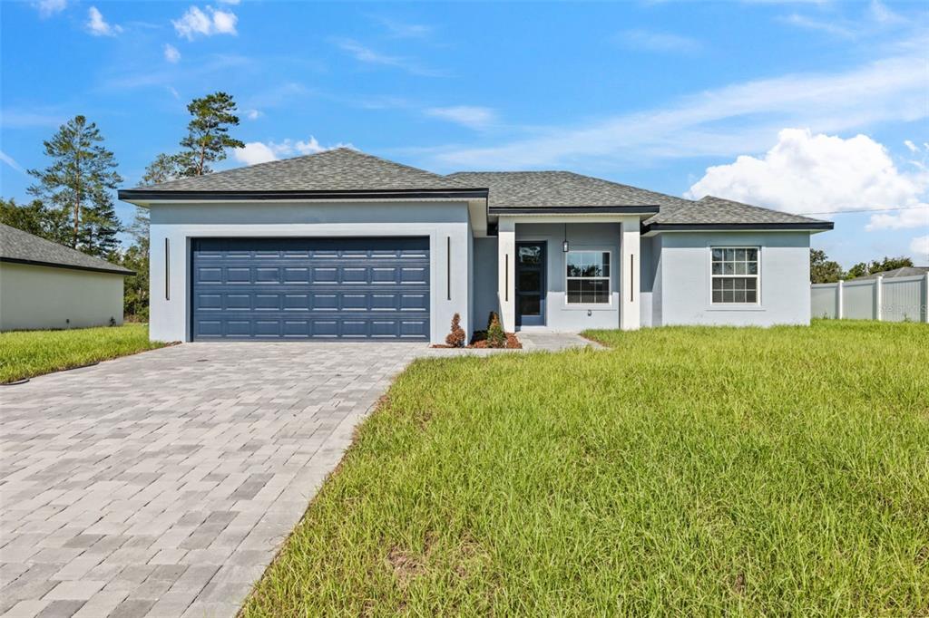 3479 Southwest 137th Loop Ocala, FL 34473 - Photo 4 of 32 a front view of a house with a garden