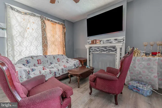 a living room with furniture a flat screen tv and a fireplace