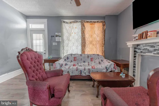 a living room with furniture a flat screen tv and a fireplace
