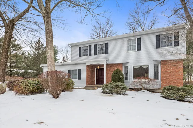 a front view of a house with yard and trees