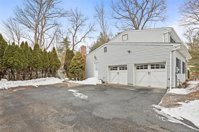 a view of a white house with a large tree