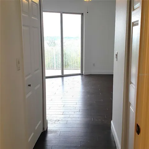 a view of an empty room and wooden floor and windows