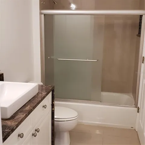 a view of a small space with wooden floor and a fan