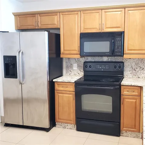 a kitchen with granite countertop cabinets and steel stainless steel appliances