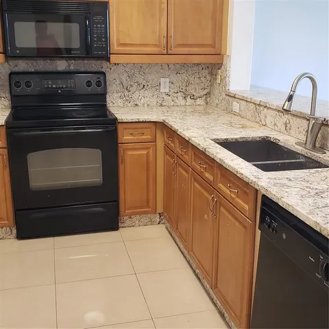 a kitchen with stainless steel appliances granite countertop a refrigerator and a microwave
