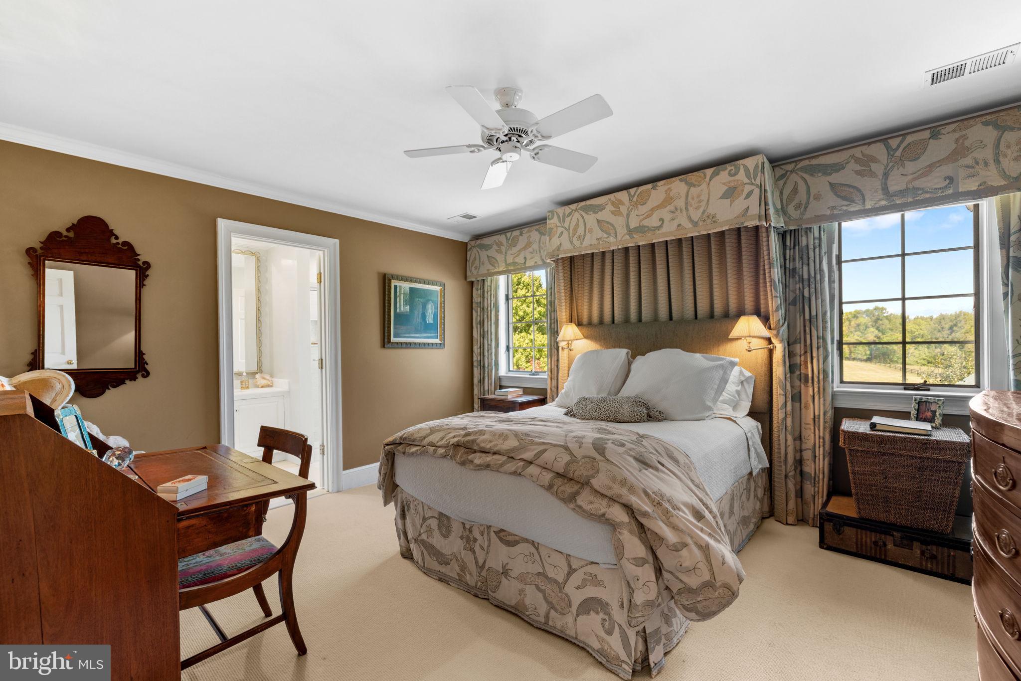 36190 Turkey Roost Road Middleburg, VA 20117 - Photo 54 of 88 a bedroom with a bed a dresser and with a large mirror next to a window