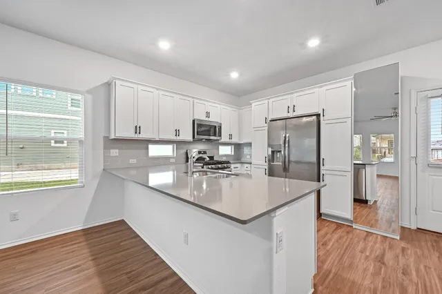 a kitchen with refrigerator cabinets and wooden floor
