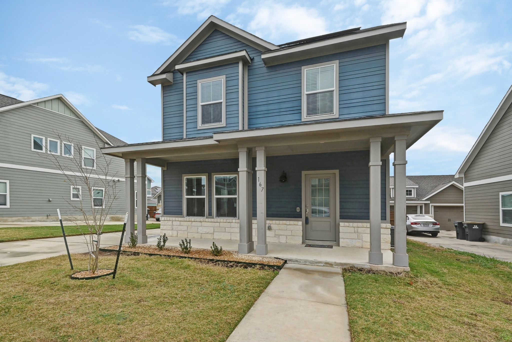 167 Rioja Kyle, TX 78640 - Photo 2 of 26 View of front of property featuring a front lawn, covered porch, and stone siding