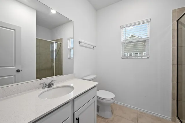 a bathroom with a granite countertop sink toilet and mirror