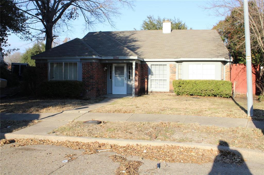 View of front of home featuring brick siding and a chimney