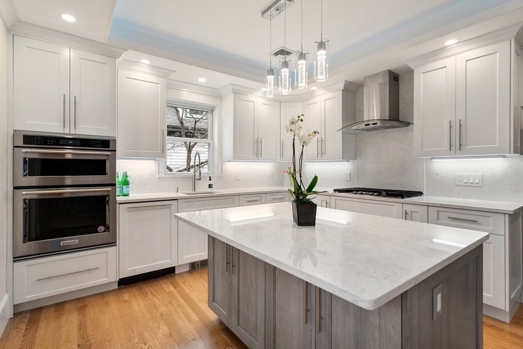88 Coolidge Street, Unit 2 Brookline, MA 02446 - Photo 1 of 14 a kitchen with stainless steel appliances granite countertop a sink dishwasher and a stove with wooden floor