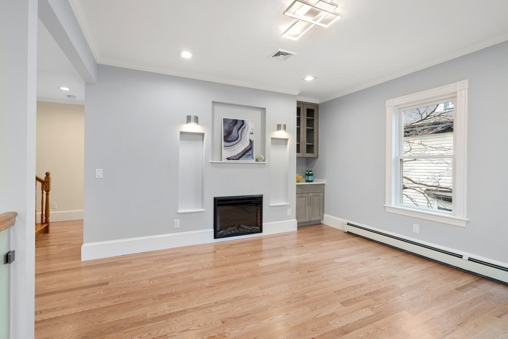 88 Coolidge Street, Unit 2 Brookline, MA 02446 - Photo 6 of 14 an empty room with wooden floor a ceiling fan and windows
