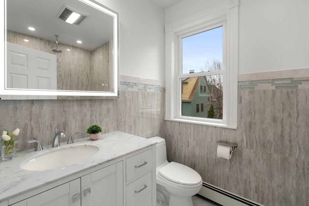 88 Coolidge Street, Unit 2 Brookline, MA 02446 - Photo 9 of 14 a bathroom with a sink a toilet and a mirror