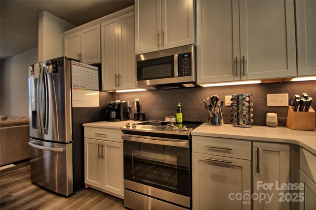 a kitchen with stainless steel appliances granite countertop a refrigerator sink and stove