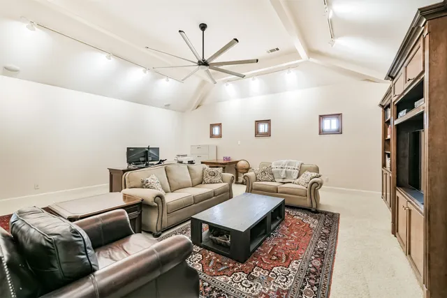 a bedroom with a bed a chandelier with a flat screen tv and furniture