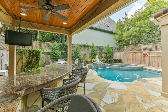 a patio with table and chairs and potted plants