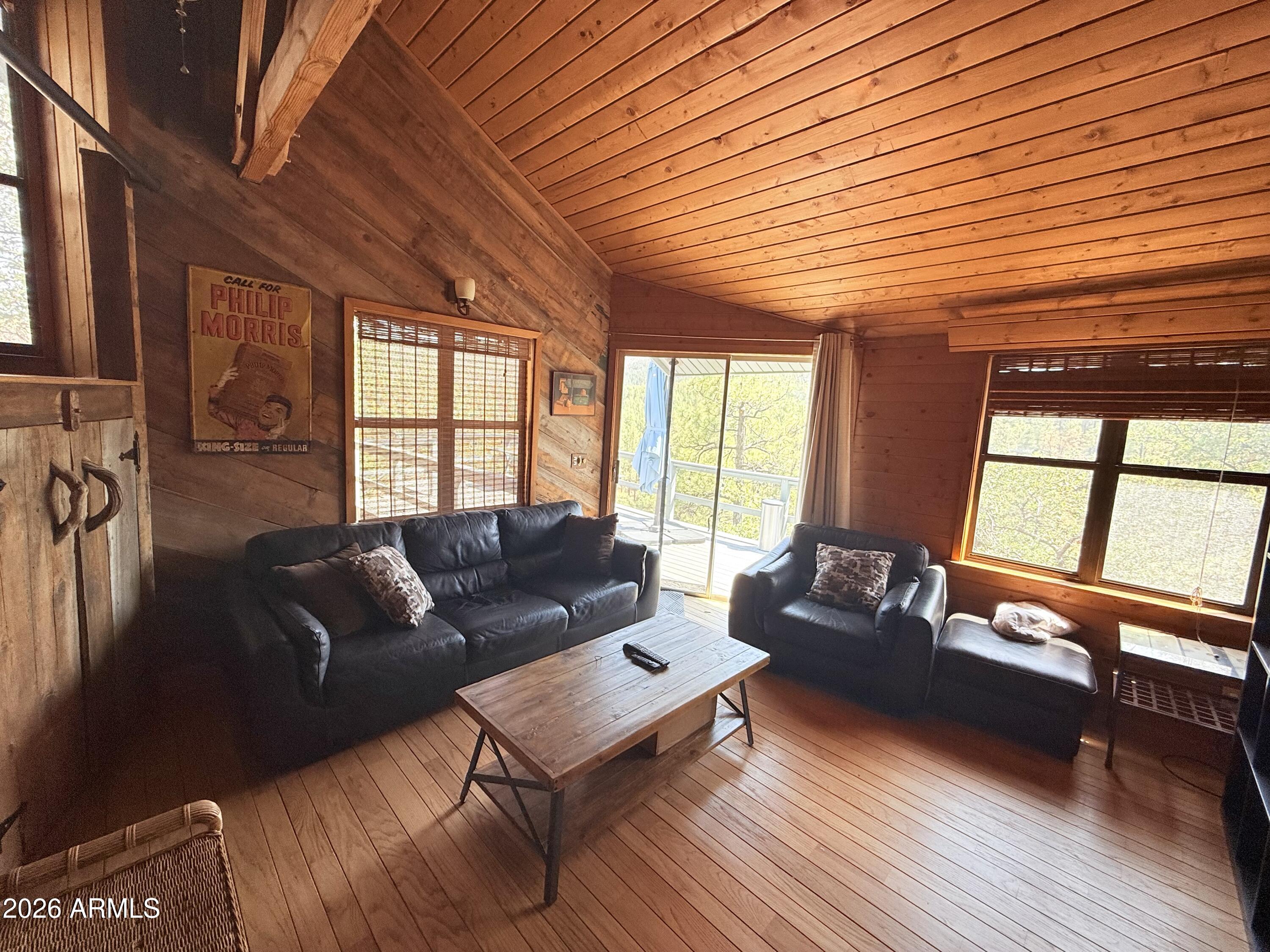 6687 Mountain View Road Crown King, AZ 86343 - Photo 10 of 18 a living room with furniture a wooden floor and a large window