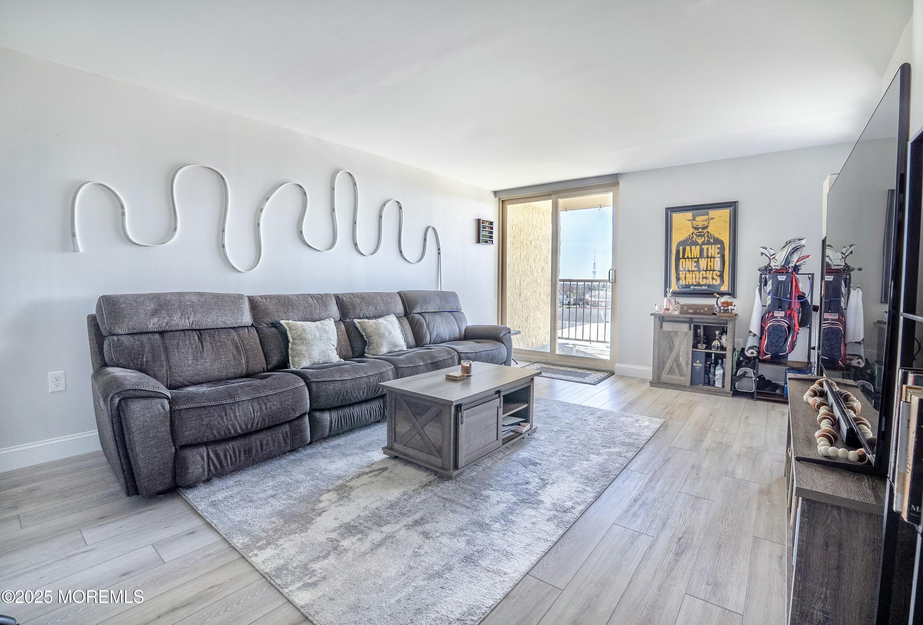 1000 River Road, Unit 6G Belmar, NJ 07719 - Photo 2 of 9 a living room with furniture a wooden floor and a window