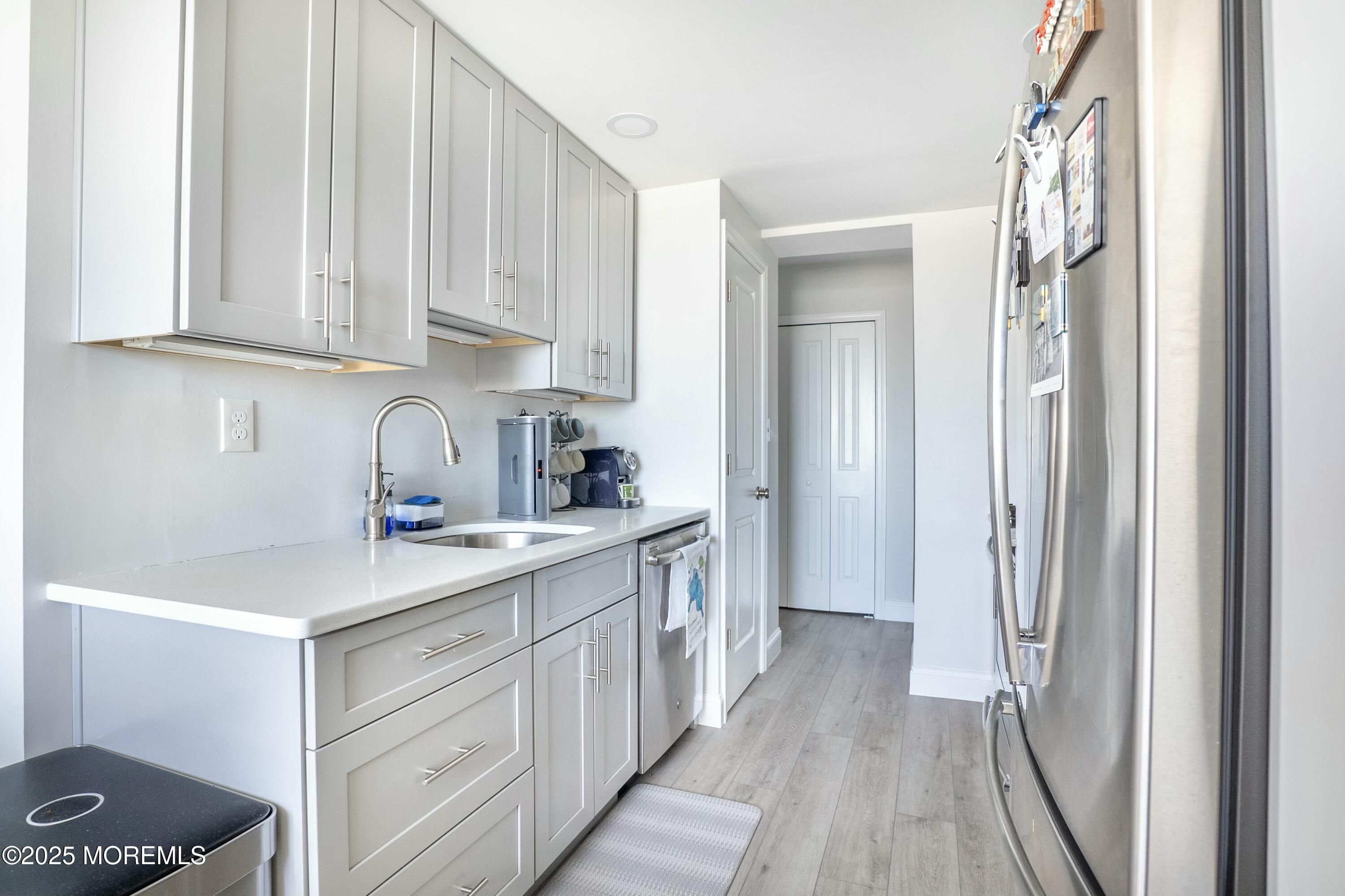 1000 River Road, Unit 6G Belmar, NJ 07719 - Photo 7 of 9 a kitchen with white cabinets and sink
