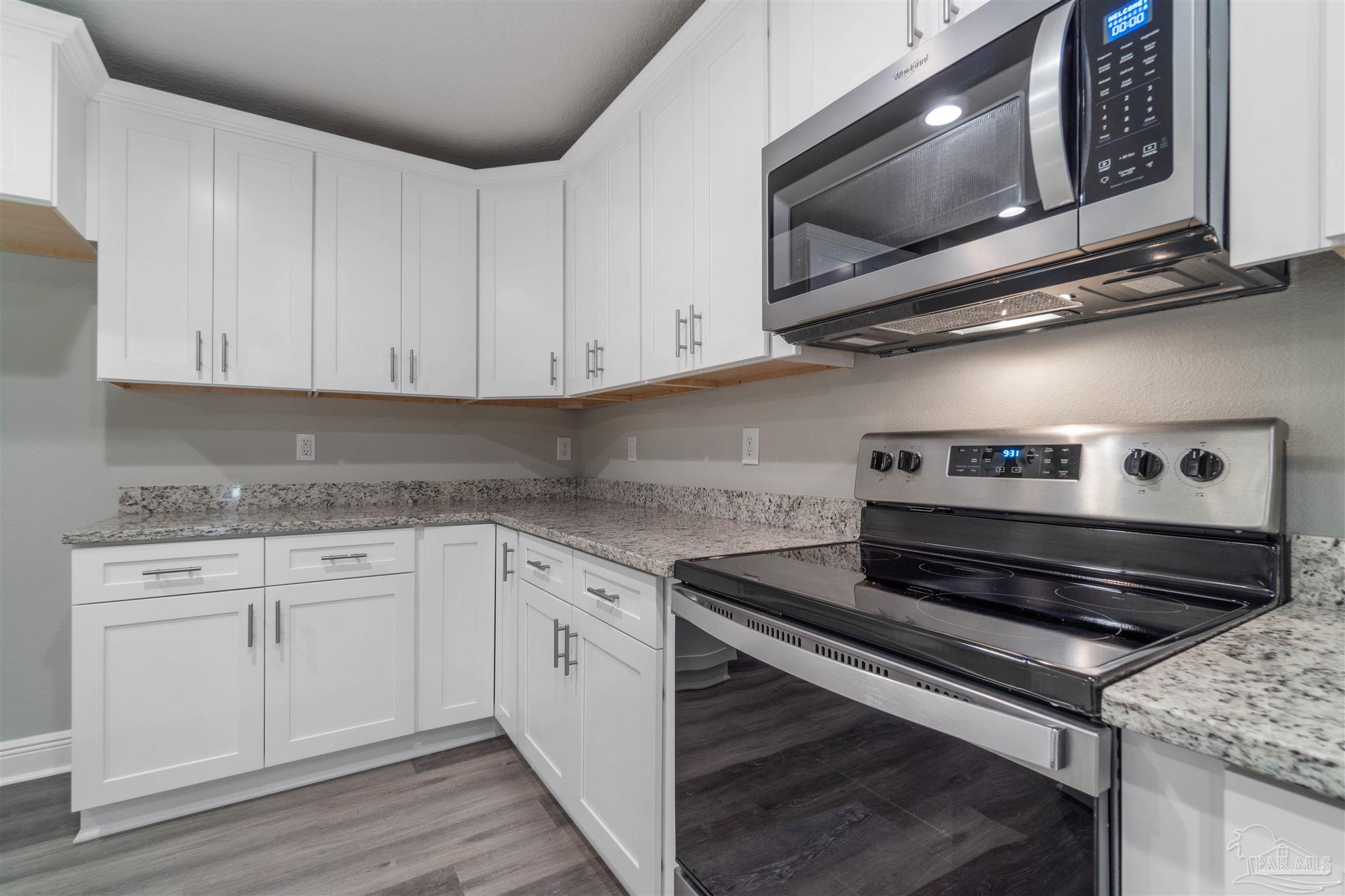 4289 Carl Booker Road Milton, FL 32583 - Photo 20 of 40 a kitchen with stainless steel appliances granite countertop a stove and a microwave