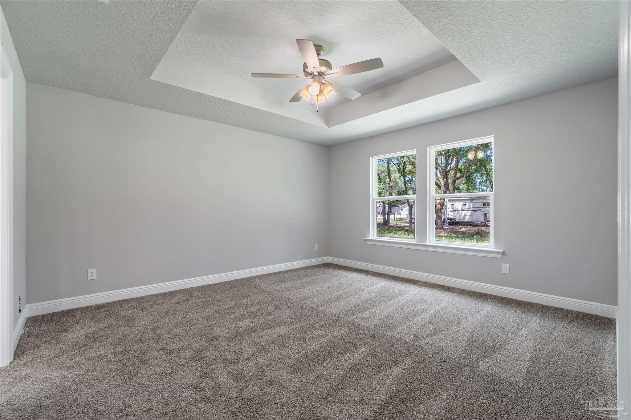 4289 Carl Booker Road Milton, FL 32583 - Photo 23 of 40 an empty room with windows and ceiling fan