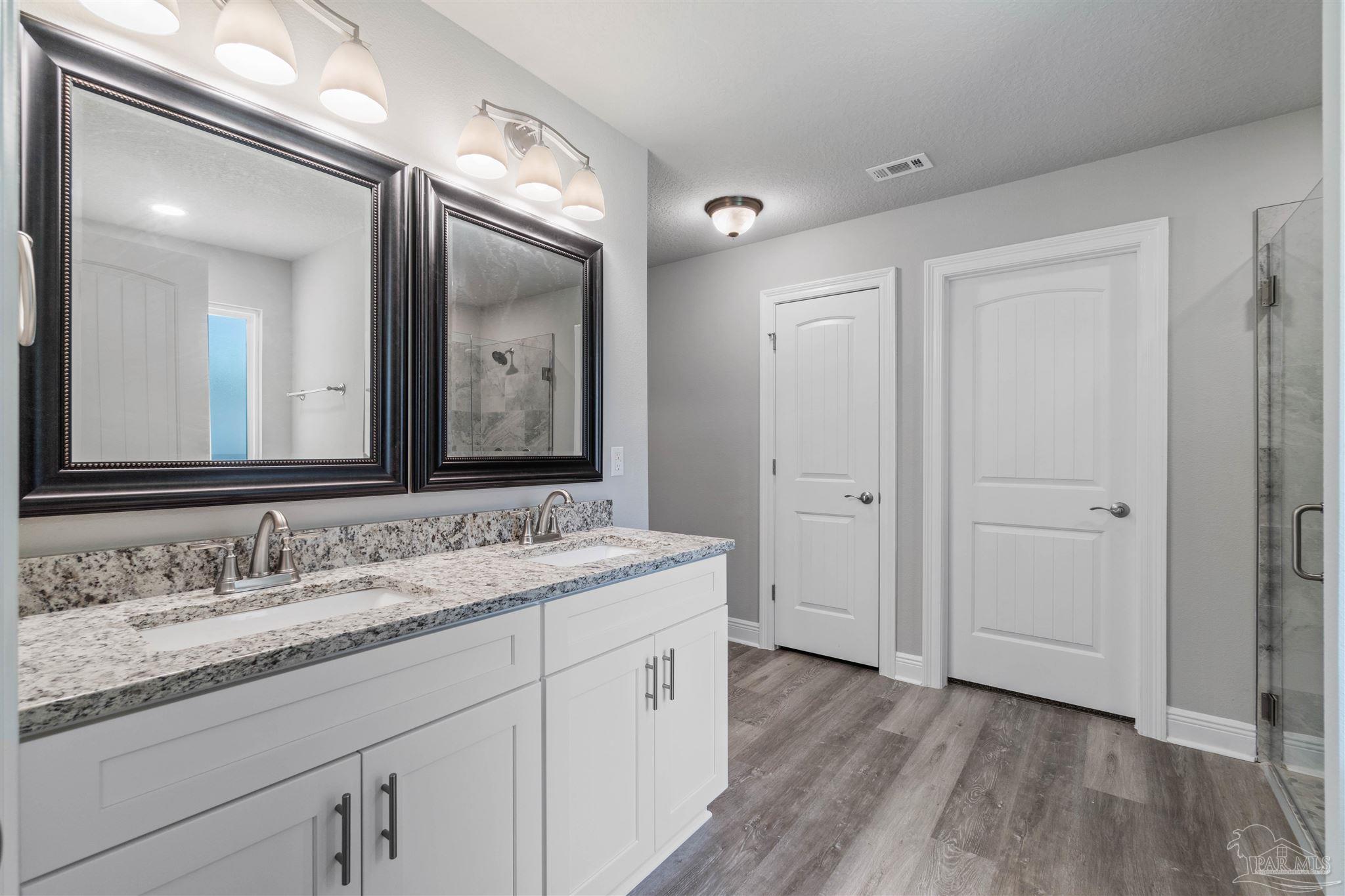 4289 Carl Booker Road Milton, FL 32583 - Photo 25 of 40 a spacious bathroom with a granite countertop sink mirror and