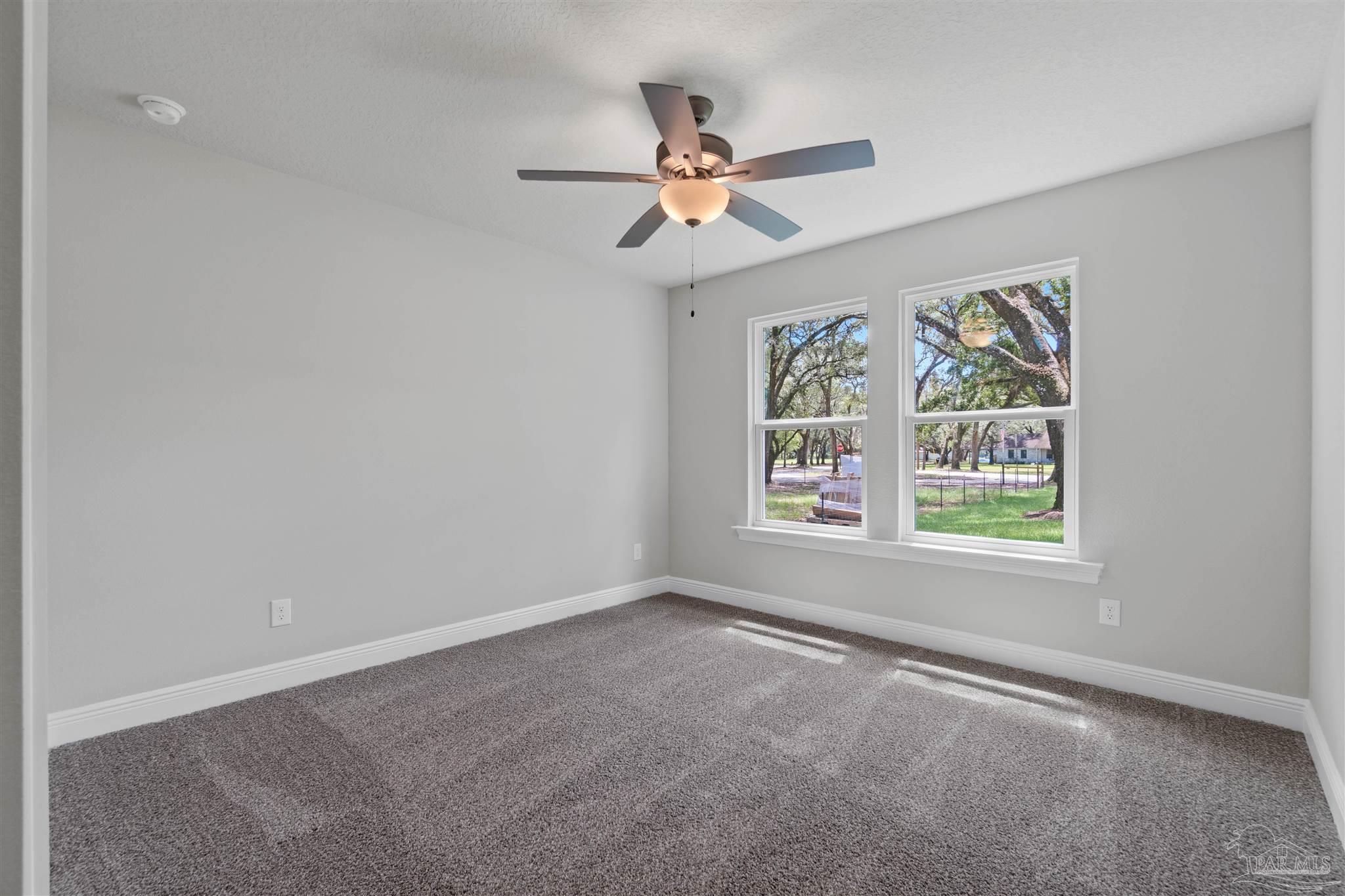 4289 Carl Booker Road Milton, FL 32583 - Photo 36 of 40 an empty room with windows and fan