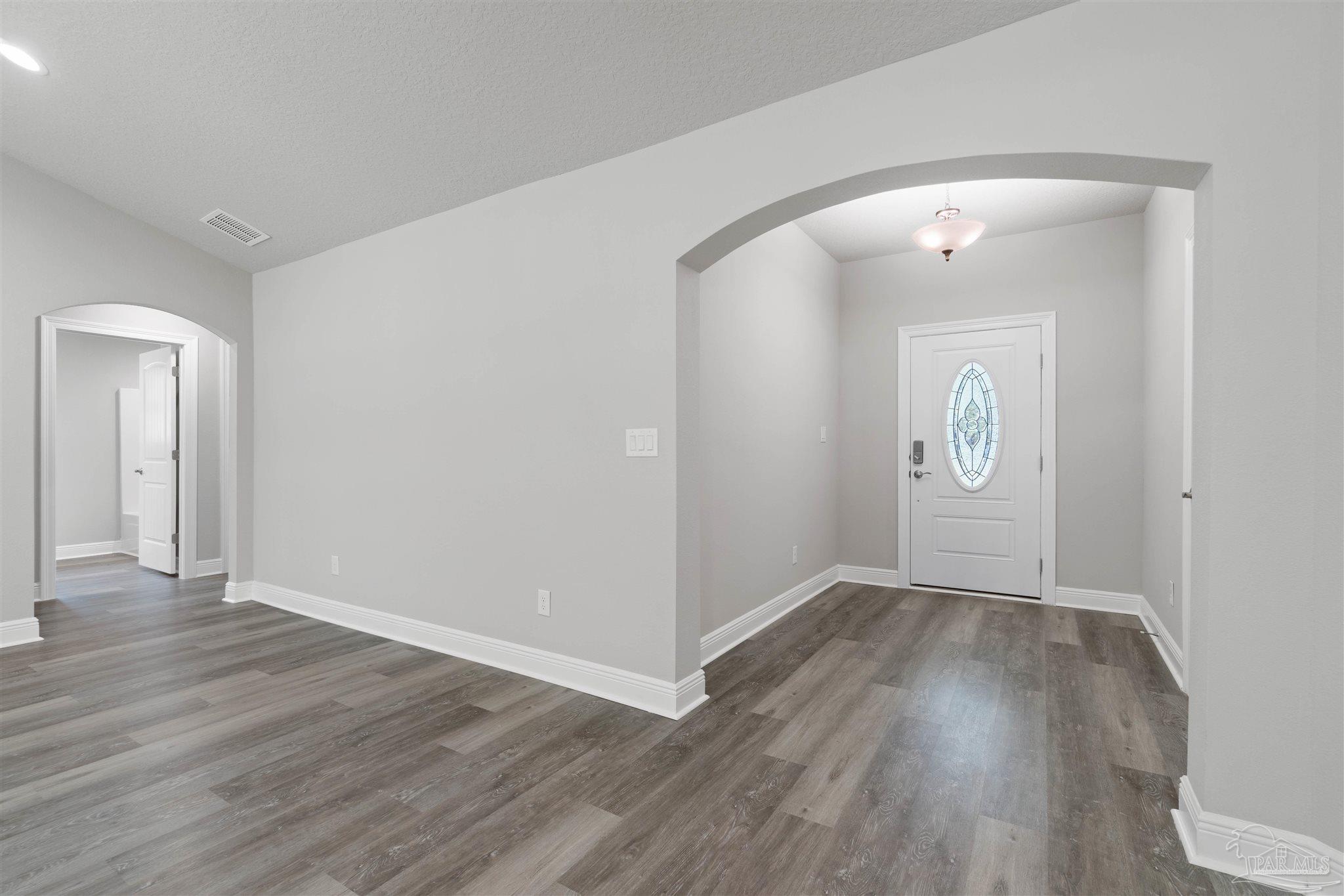 4289 Carl Booker Road Milton, FL 32583 - Photo 9 of 40 an empty room with wooden floor and mirror