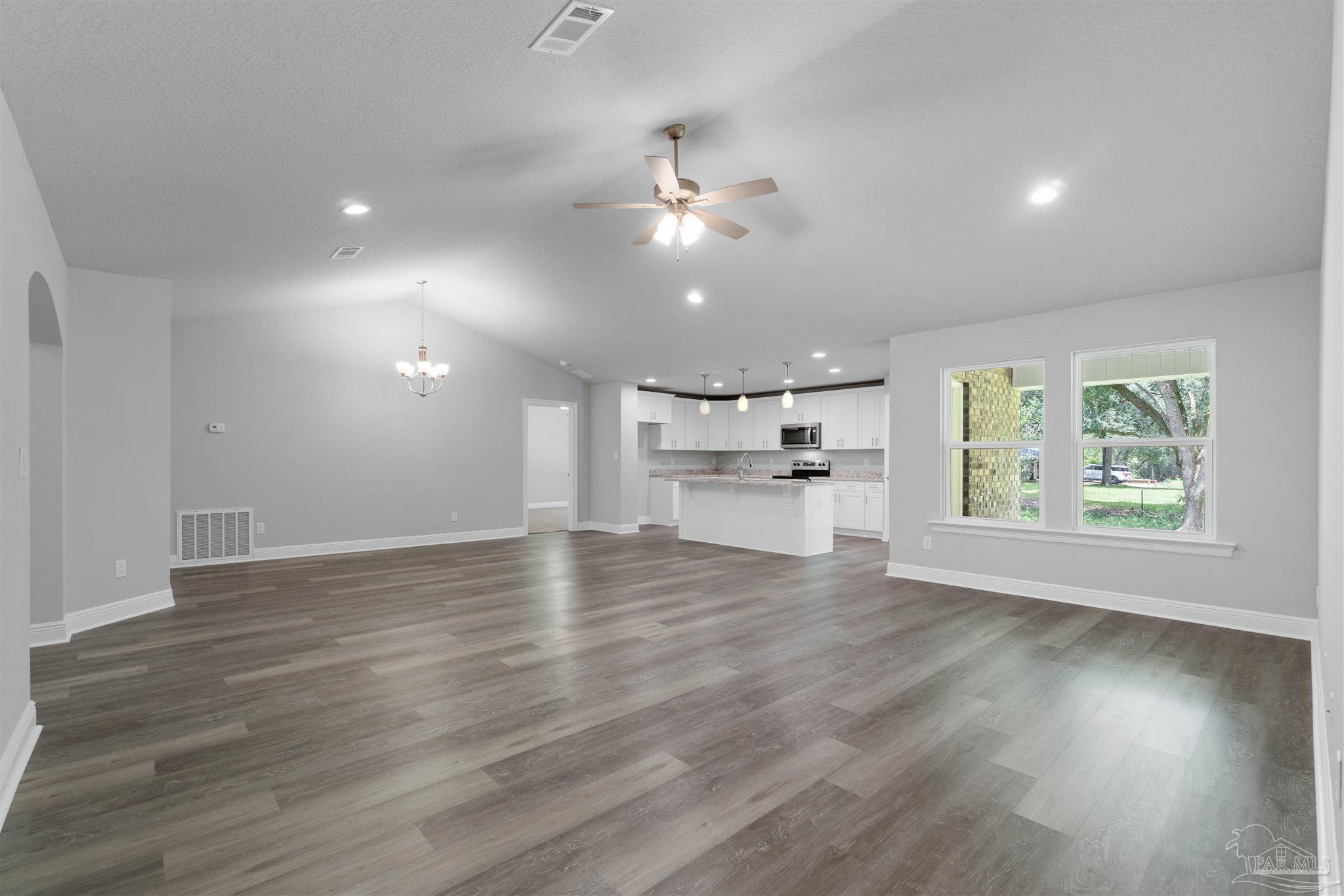 4289 Carl Booker Road Milton, FL 32583 - Photo 10 of 40 an empty room with wooden floor ceiling fan and windows