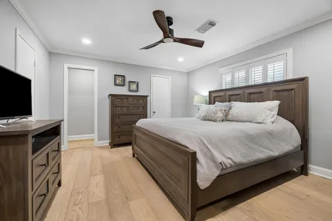 a spacious bedroom with a bed and a flat screen tv