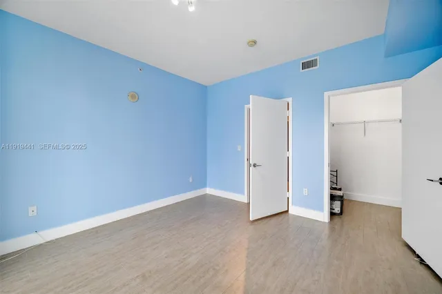 an empty room with wooden floor and closet