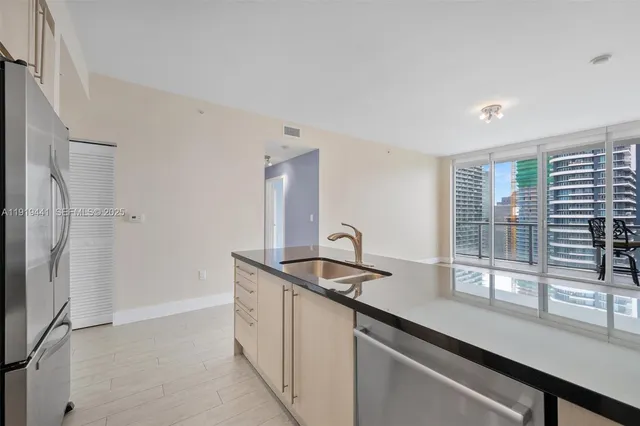 a kitchen with stainless steel appliances granite countertop a sink and a refrigerator