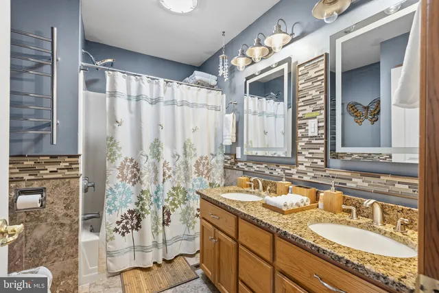 a bathroom with double vanity and a mirror