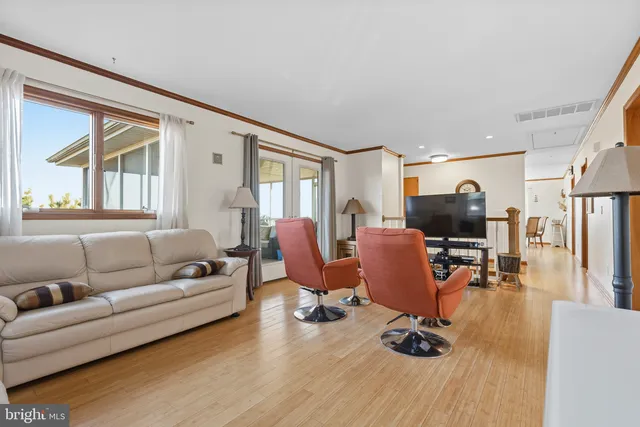 a living room with furniture flat screen tv and a large window