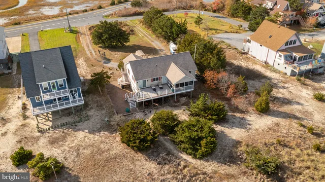 an aerial view of a house with a yard and large tree