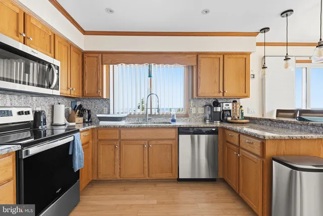 a kitchen with stainless steel appliances granite countertop a stove a sink dishwasher and a refrigerator