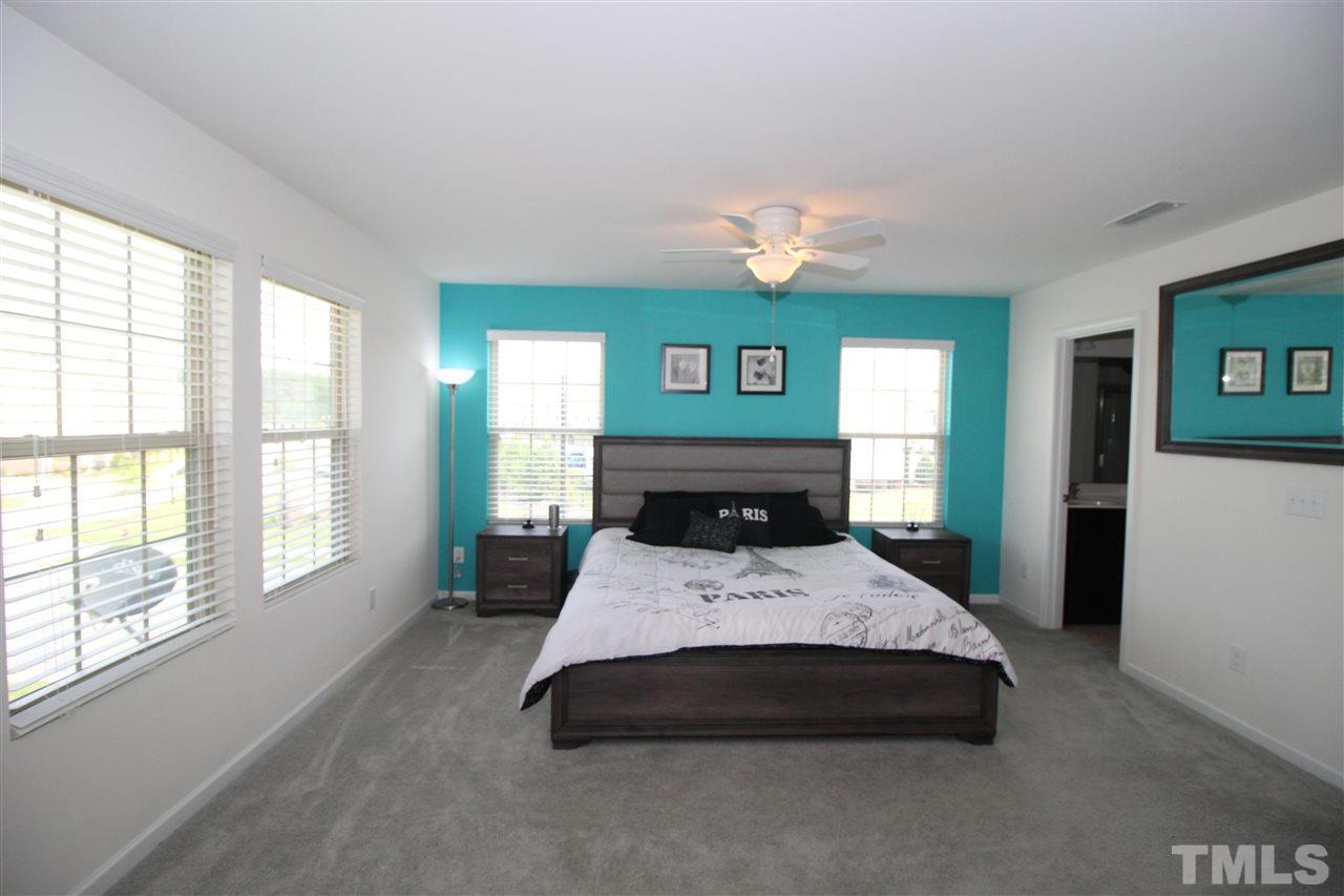 1045 Grand Ridge Drive Rolesville, NC 27571 - Photo 13 of 23 a large bedroom with a bed and a large window