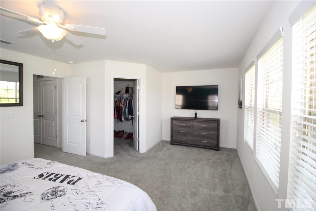 1045 Grand Ridge Drive Rolesville, NC 27571 - Photo 14 of 23 a bedroom with a bed and a flat screen tv
