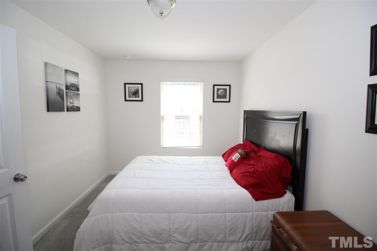 1045 Grand Ridge Drive Rolesville, NC 27571 - Photo 19 of 23 a bedroom with a bed and a lamp