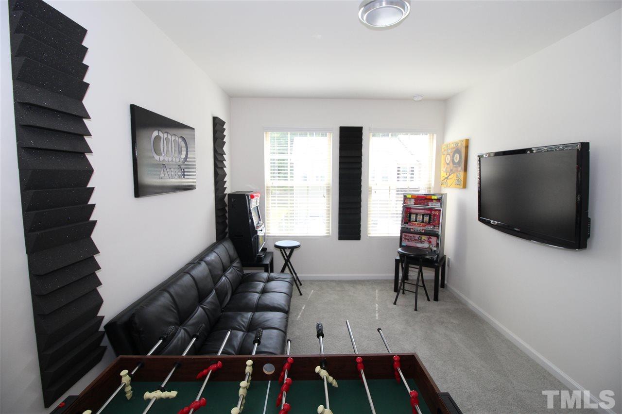 1045 Grand Ridge Drive Rolesville, NC 27571 - Photo 21 of 23 a living room with furniture and a flat screen tv